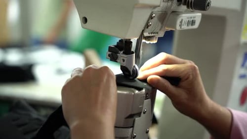 Close up sewing machine of worker sewing in factory