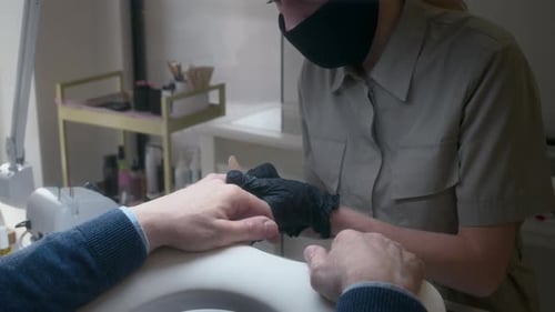 Man Receiving Manicure Treatment at Nail Salon
