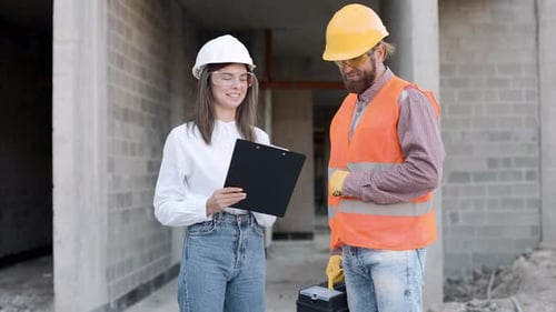 Workers discuss project details on construction site in slow motion