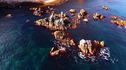 Stones are visible in the water with waves flowing around them.