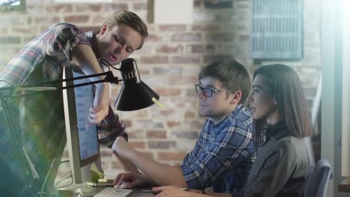 Equipe de jovens criativos está discutindo um projeto de trabalho na tela do computador.