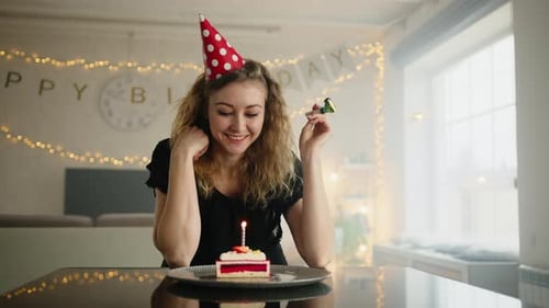 Woman in a Party Cap Blowing a Party Wistle in a Birthday Celebration