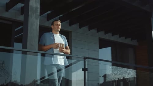 Man Enjoying Morning Coffee on Modern Balcony