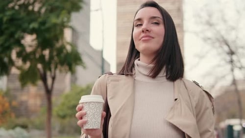Confident Young Woman Walking with Coffee in the City