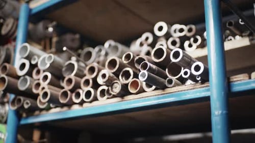 Video Metadata Title: Hollow Steel Pipes and Tubes Stacked on Shelf in Metal Workshop