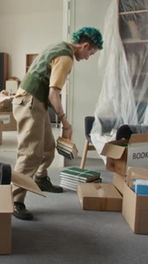People Packing Belongings into Cardboard Boxes in Apartment