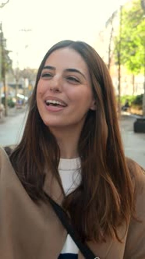 Vertical Video Young Attractive Woman Making a Video Call with Smartphone on the Street in a City