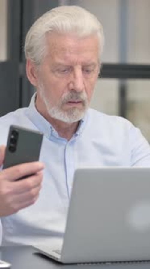 Senior Man Working with Laptop and Mobile Phone