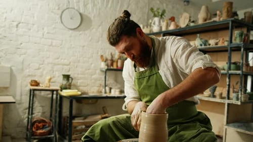 A man makes a clay pot on a ceramic wheel Ceramics Close-up A potter does pottery handicraft