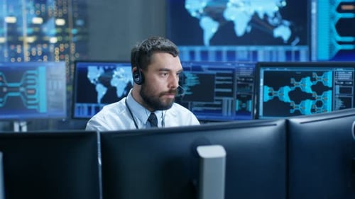 Im Systemüberwachungsraum spricht der Dispatcher ins Headset, beobachtet die korrekte Funktion des F