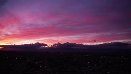 Panoramic aerial view with the city below and a stunning sunset beyond the horizon