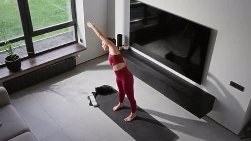 Woman Stretching on Yoga Mat Inside Modern Home