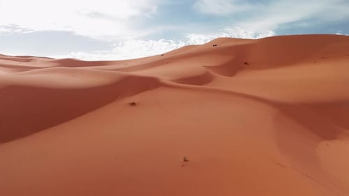 Weite Sahara-Wüste Atemberaubende orangefarbene Sanddünen unter bewölktem blauem Himmel