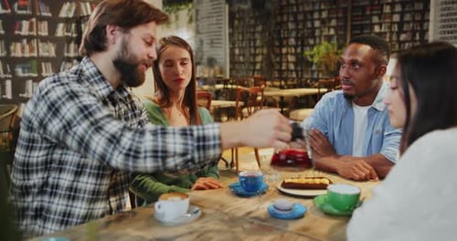 Friends Gather at Coffee Shop Talking Over Drinks