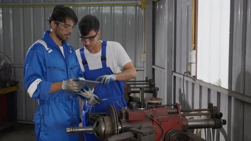 Supervisor training with young man sanding or iron at industrial factory, mechanic working job.