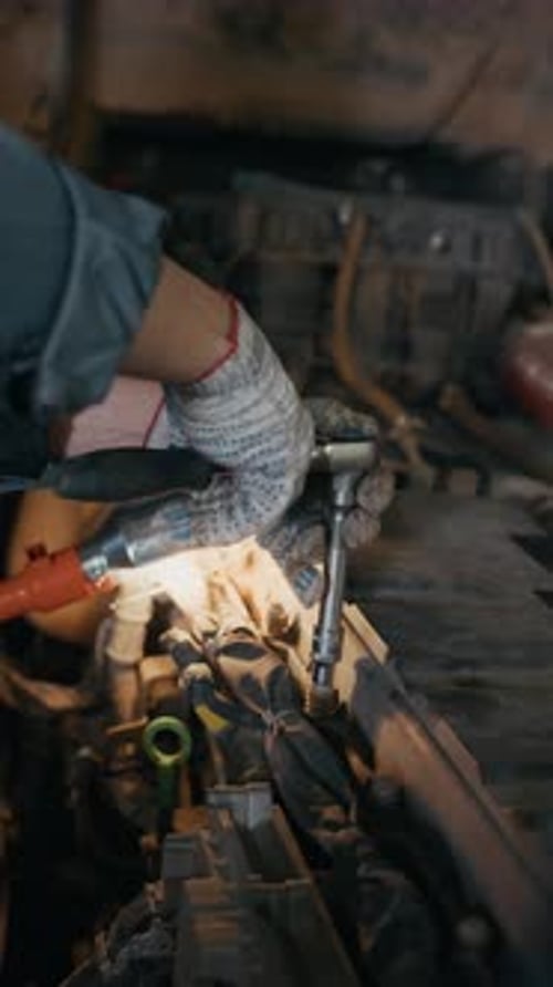 Hands of Worker Using Wrench in Garage