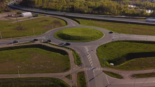 Drone descend above Katlakalns roundabout showing lively traffic movement, road entries