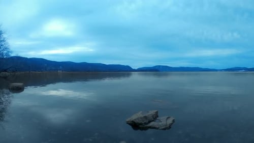 A time lapse of a vast, wide river on a cloudy, dreary, blue day. This is on the Hudson River in New