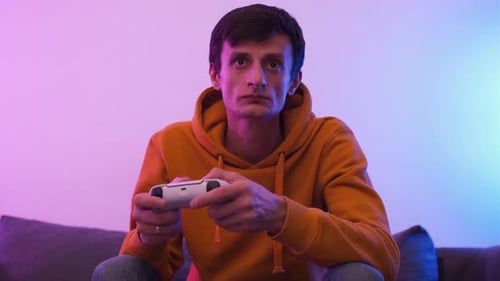 Man Playing Video Game with Controller on Couch