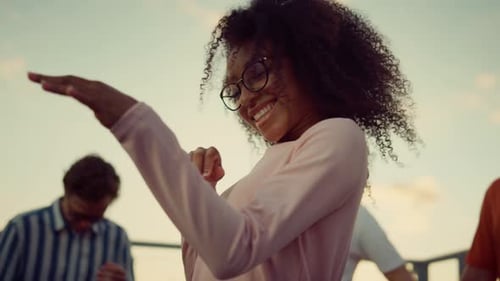Woman Smiling and Dancing Outdoors With Friends