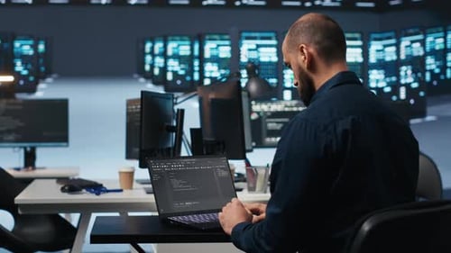 Computer Scientist Using Laptop Device to Do Programming in Data Center