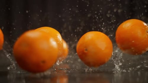 Eine große Anzahl von Orangen fällt auf den Tisch und bildet Spritzer