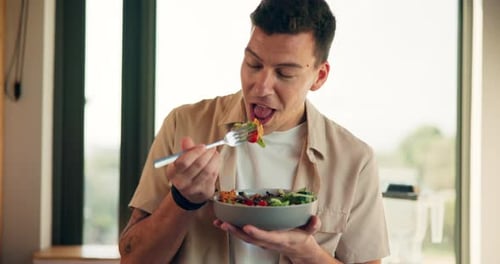 Young Man Enjoys Healthy Salad Indoors