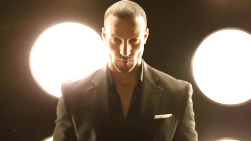 Handsome and stylish man in front of a wall of lights