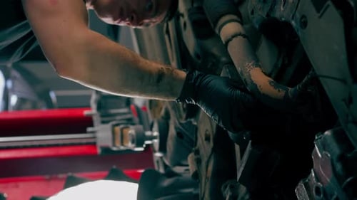 Vertical Video Close Up an Auto Mechanic at Service Station Checks a Car Being Lifted on a Lift