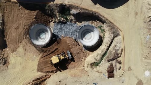 El cargador frontal mueve la tierra alrededor del sitio de construcción, vista desde arriba