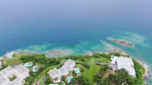 Aerial forward over luxury seaside houses on Crete coast in Greece.