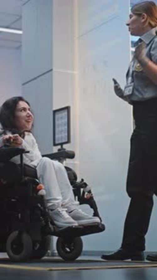 Security Checkpoint in Airport Terminal Female Security Officer Inspects Woman in Wheelchair