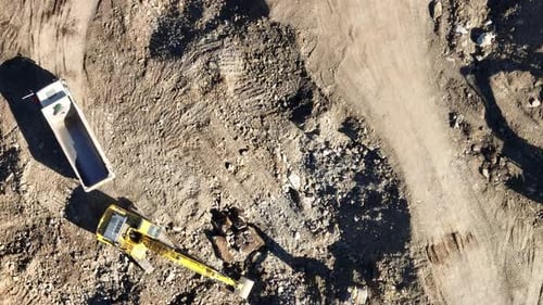 Industrial Mine Excavators are Digging the Soil in the Construction Site and Loading Trucks