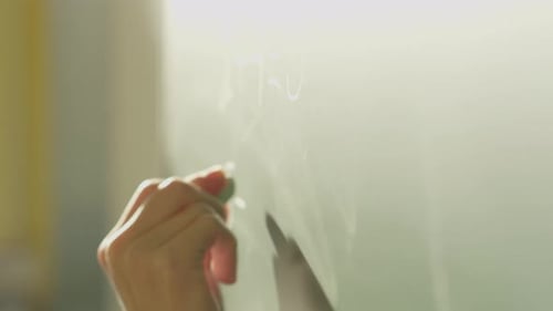 A Girl Student Writes on a Green Board