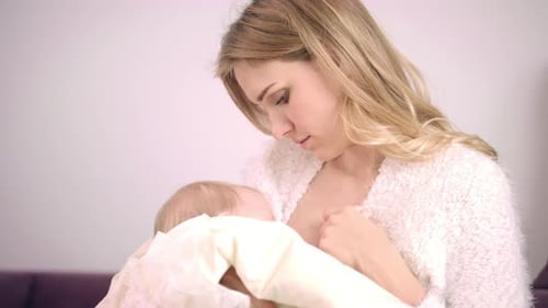 Happy mother breastfeeding newborn baby girl a close up portrait of love and care