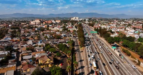 Streets and roads of Los Angeles filled with multiple cars. Busy lifestyle of metropolis at daytime.