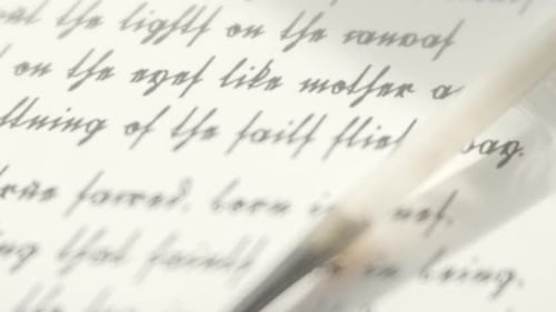 White Feather Quill on Handwritten Text Close Up