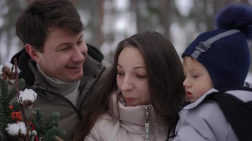 Family Enjoys Holiday Flowers in Winter Forest