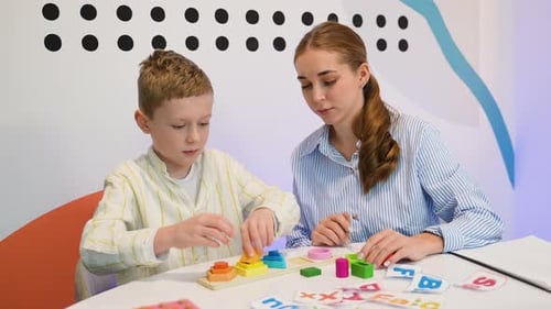 Young Boy Learning Shapes and Colors with a Tutor