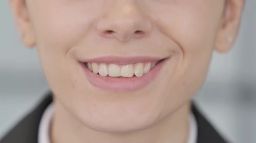 Close Up of Smiling Young Woman Lips and Teeth
