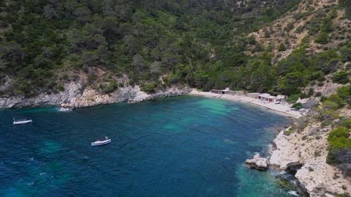 turquoise water Ibiza secret rocky cove bay. Smooth aerial view flight drone