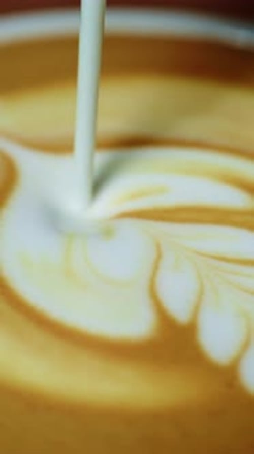 Enjoying Latte Art at a Cozy Cafe in the Morning with Rich Flavors and Inviting Aromas
