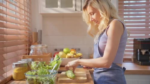 Woman Prepares Healthy Salad in Sunny Kitchen