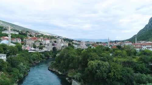 Drone flying over the magical river Neretva towards the old bridge in Mostar, Bosnia and Herzegovina