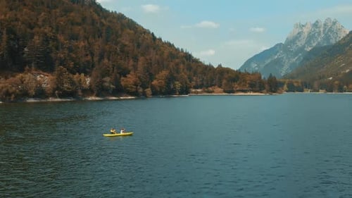 A Couple Kayaking in the Middle of a Lake in Italy, Lago del Predil During a Clear Summer Day. Aeria