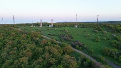 View of the Hills Covered with Vegetation with Cell Towers Against the Backdrop of Fields and a