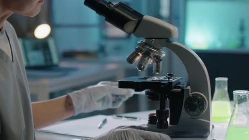 Unrecognizable Female Scientist Studying Bacteria under Microscope