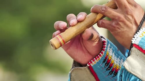 Indigener Musiker spielt traditionelle Flöte und Panflöte während einer kulturellen Feier