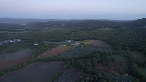 Luftaufnahme einer Landvilla mit Olivenbäumen und Pool bei Sonnenuntergang, Italien.