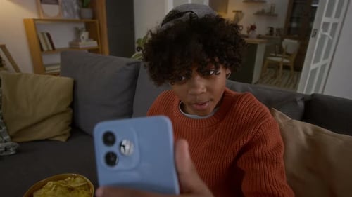 Teen Video Chatting on Smartphone in Living Room